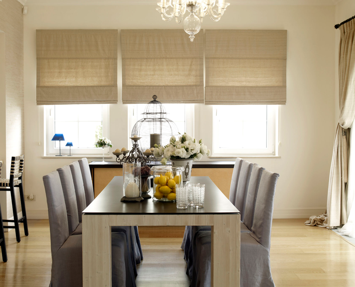 Roman shades on three dining room windows are pet-friendly window treatments.