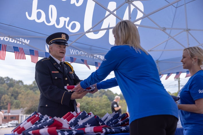 Woman receiving a flag at a Window World Military Initiative event.