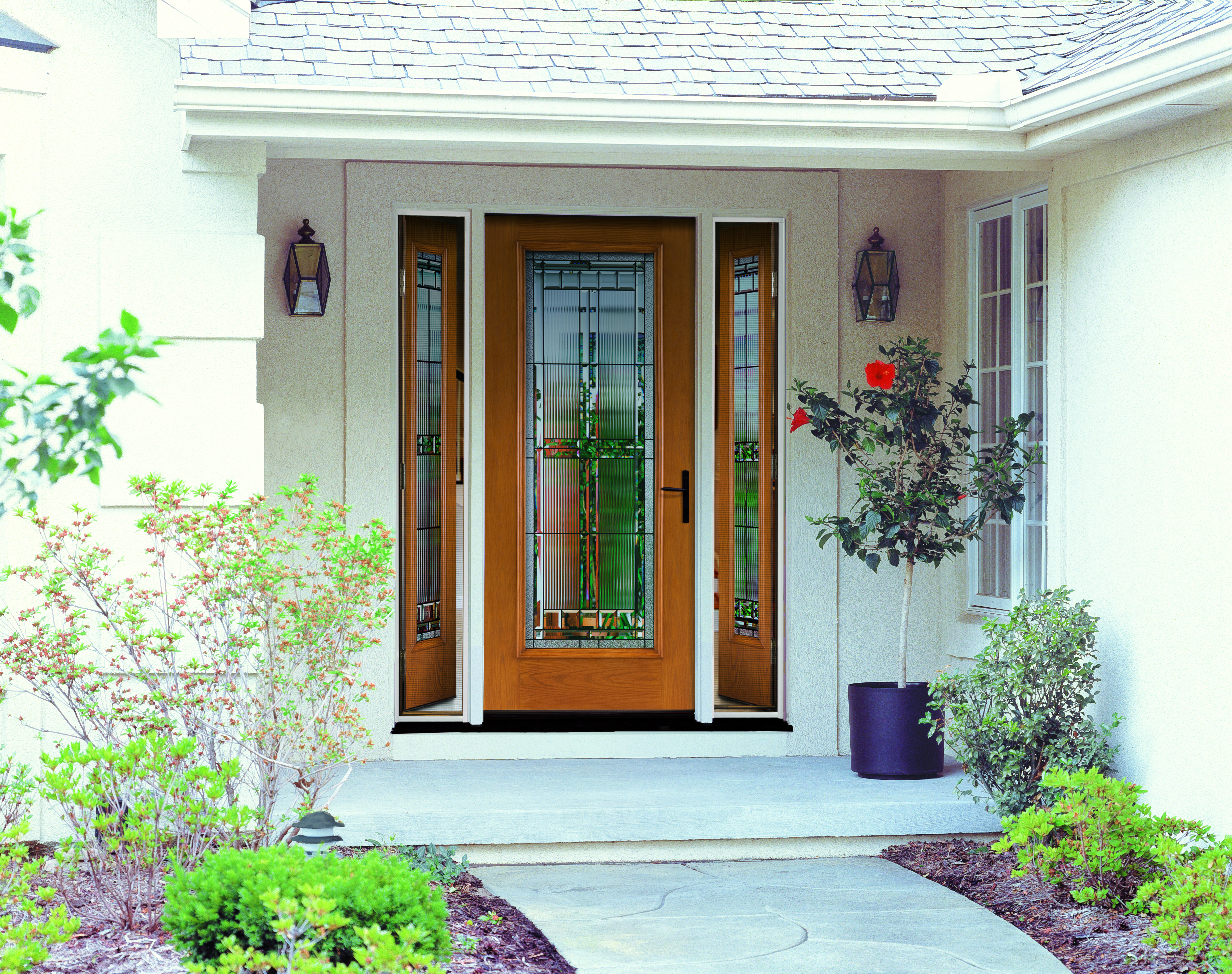 A front door flanked by sidelights, all of which feature decorative glass and woodgrain texture.