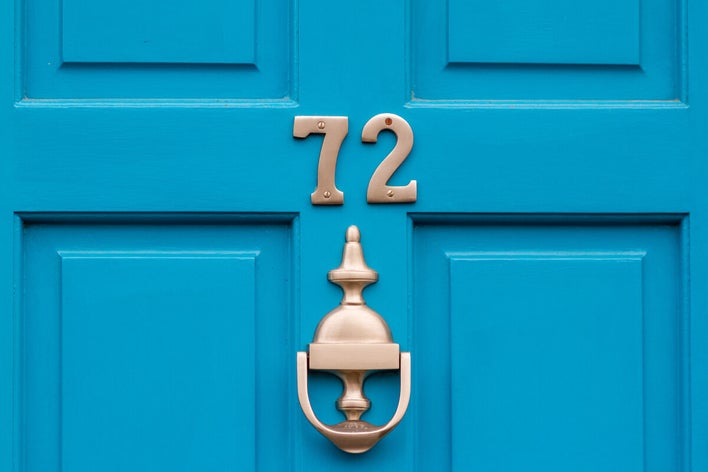 a blue front door with the number “72”