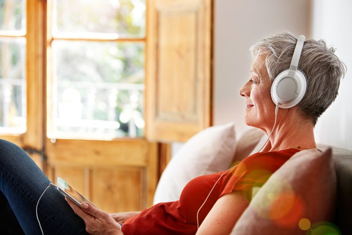 Woman enjoying listening to her device with headphones attached as they decrease noise pollution.