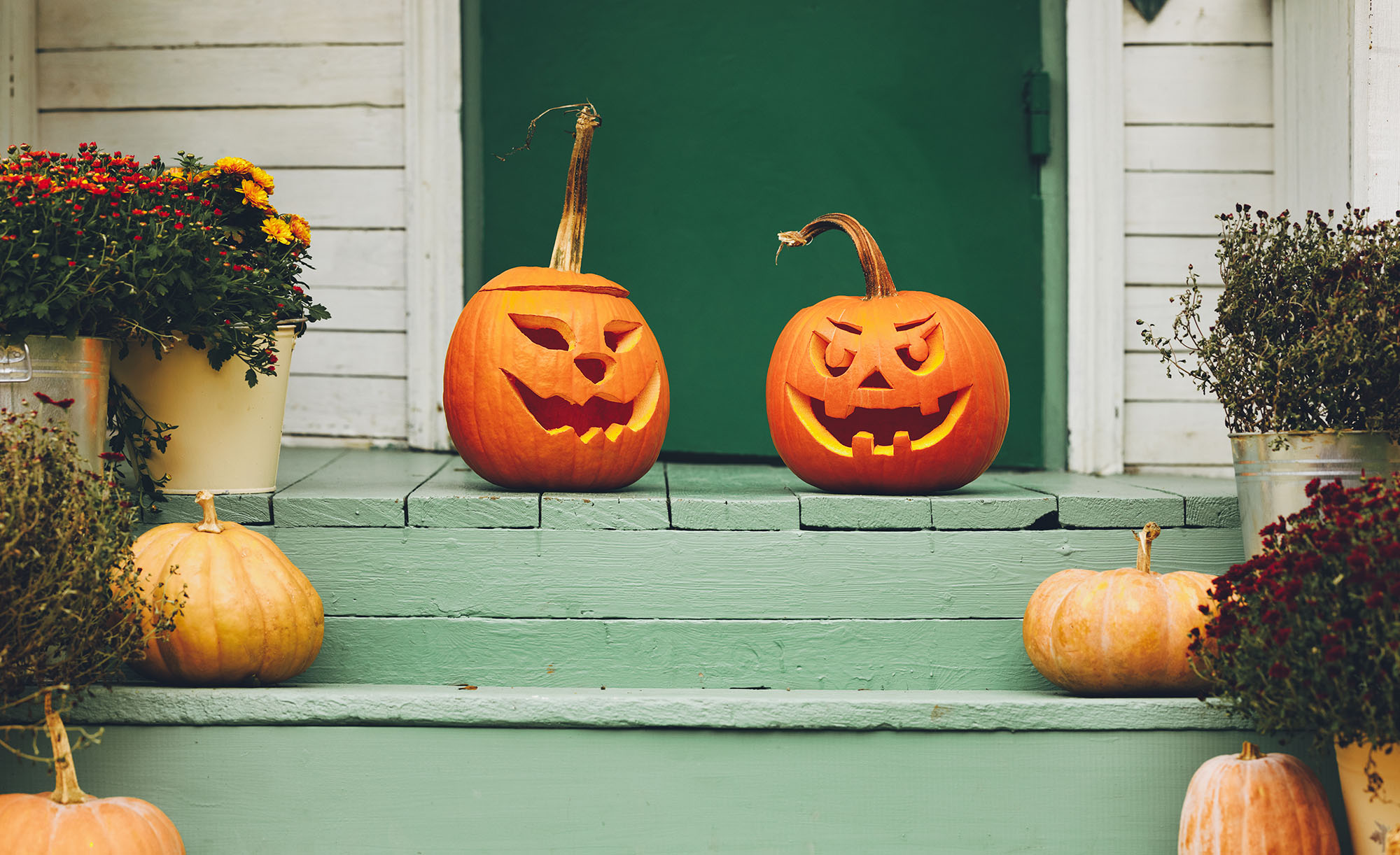 Jack-o’-lanterns on the doorsteps of a home as Halloween door décor