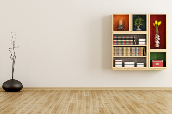 A modern wooden bookcase mounted on a white wall