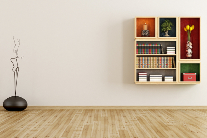 A modern wooden bookcase mounted on a white wall A modern wooden bookcase mounted on a white wall