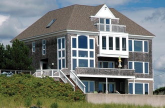 Impact-resistant picture and architectural shaped windows with elegant white vinyl frames and laminated glass.