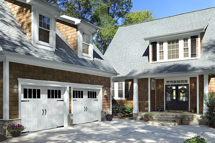 White garage doors on a cottage-style home