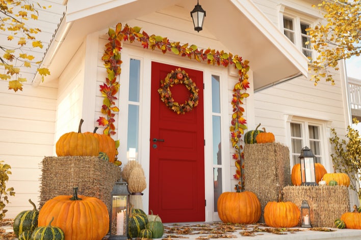 A red front door with fall décor