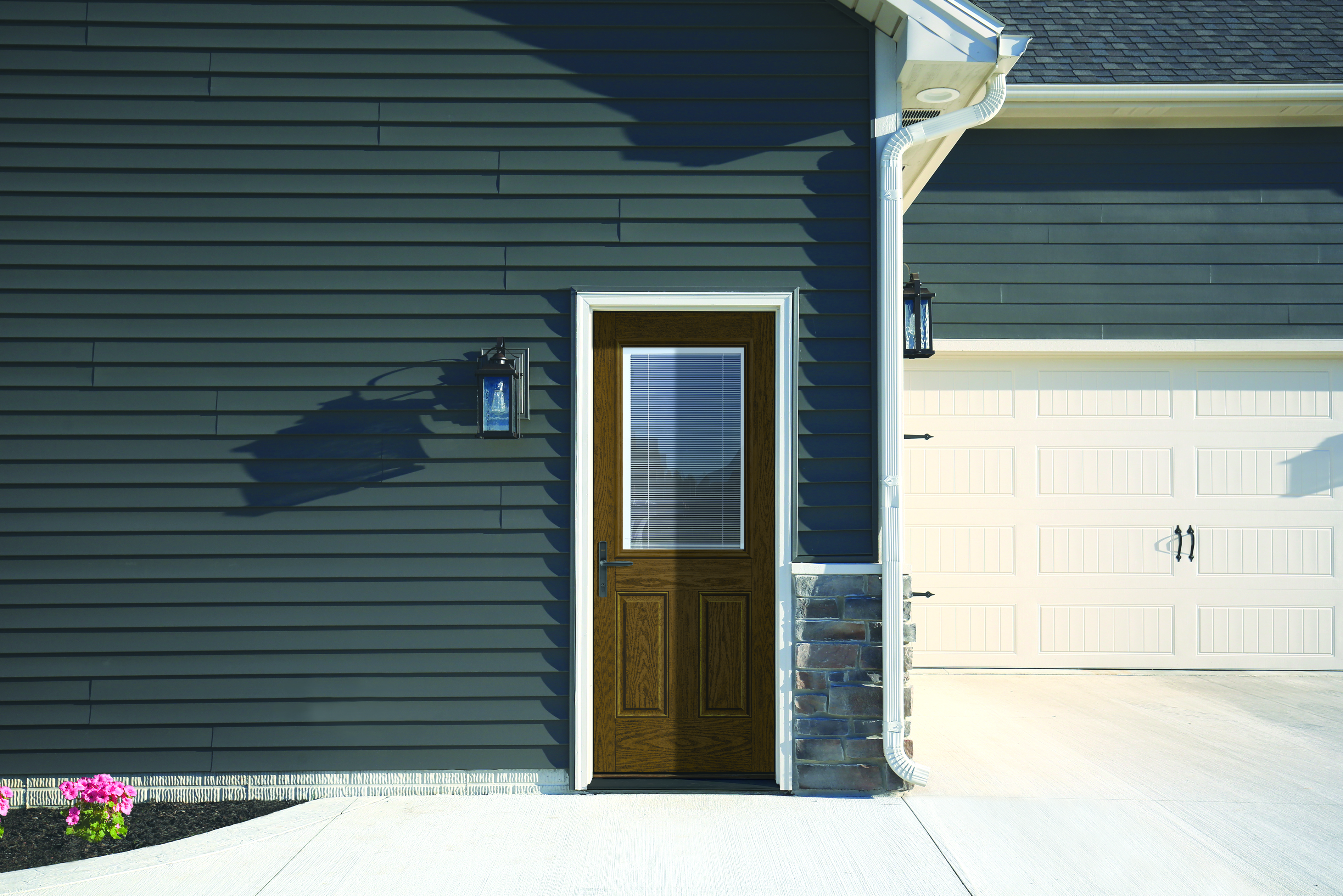 A Barley colored Fiber-Classic® Fiberglass Entry Door with internal blinds on a house with dark-colored siding