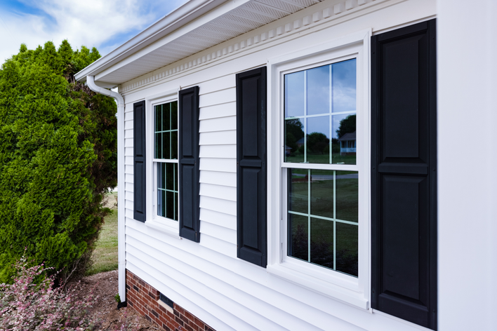 House with high-contrast black exterior shutters and white siding.