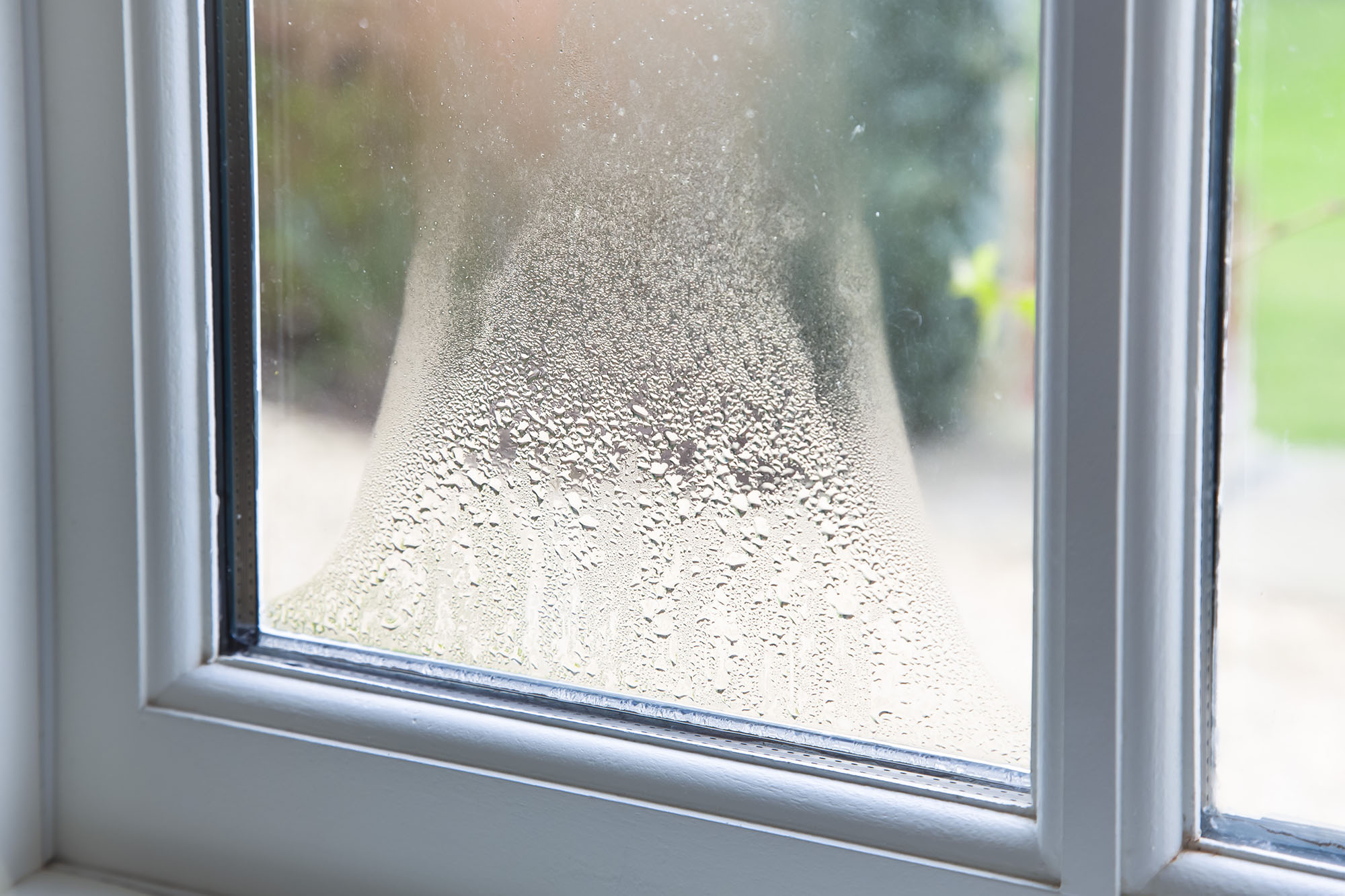 Close-up of condensation between the panes of a window.
