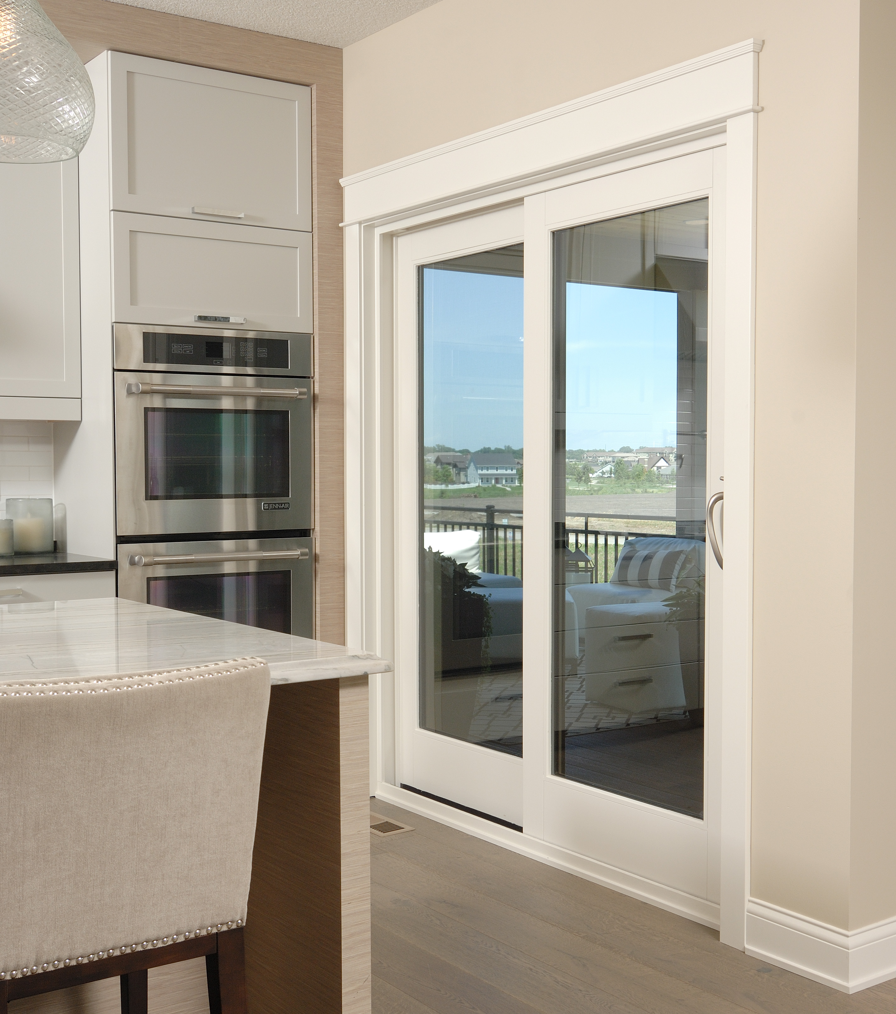A kitchen with a white sliding patio door near the stove.