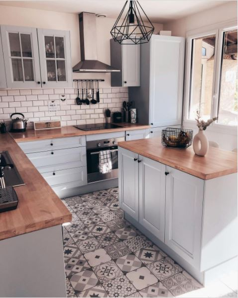 A wonderful kitchen with blue cabinets and a patterned floor