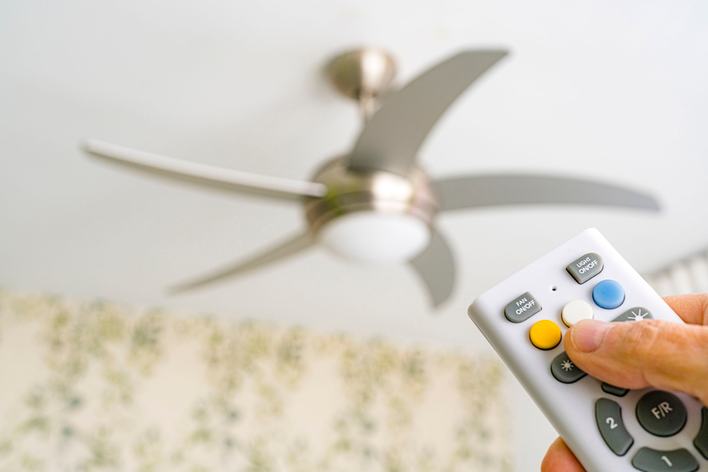 A remote control ceiling fan being reversed to push warm air down to improve winter<br>comfort.