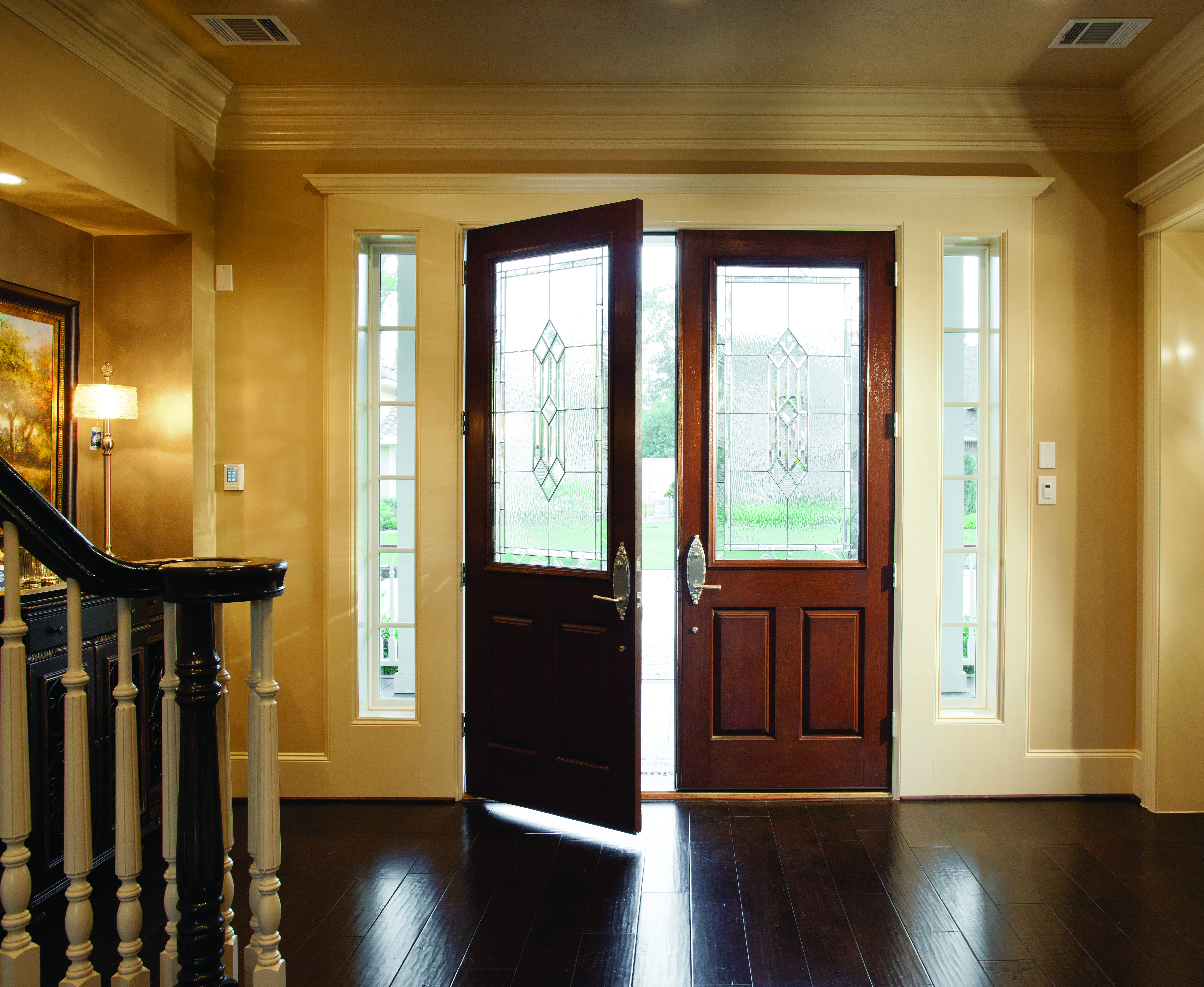 Open fiberglass exterior doors with decorative privacy glass to obscure the home’s<br>interior.