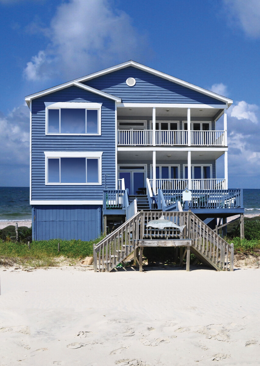 blue beachfront home featuring white-trimmed end-vent slider windows with ocean view backdrop