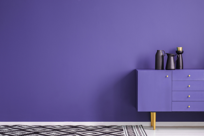Purple wall paint and dresser inside of a home