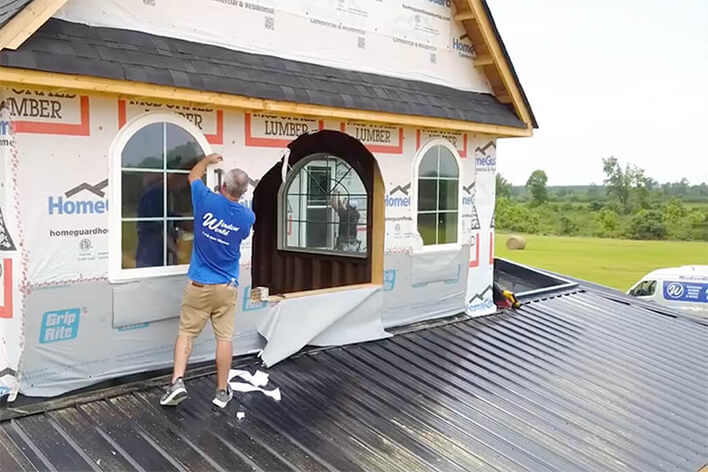 Window World installation technician replacing exterior windows on a home