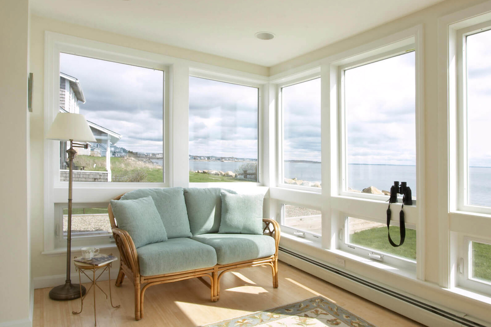 A sitting area in a beachfront home with windows that will need to prepared for hurricane season