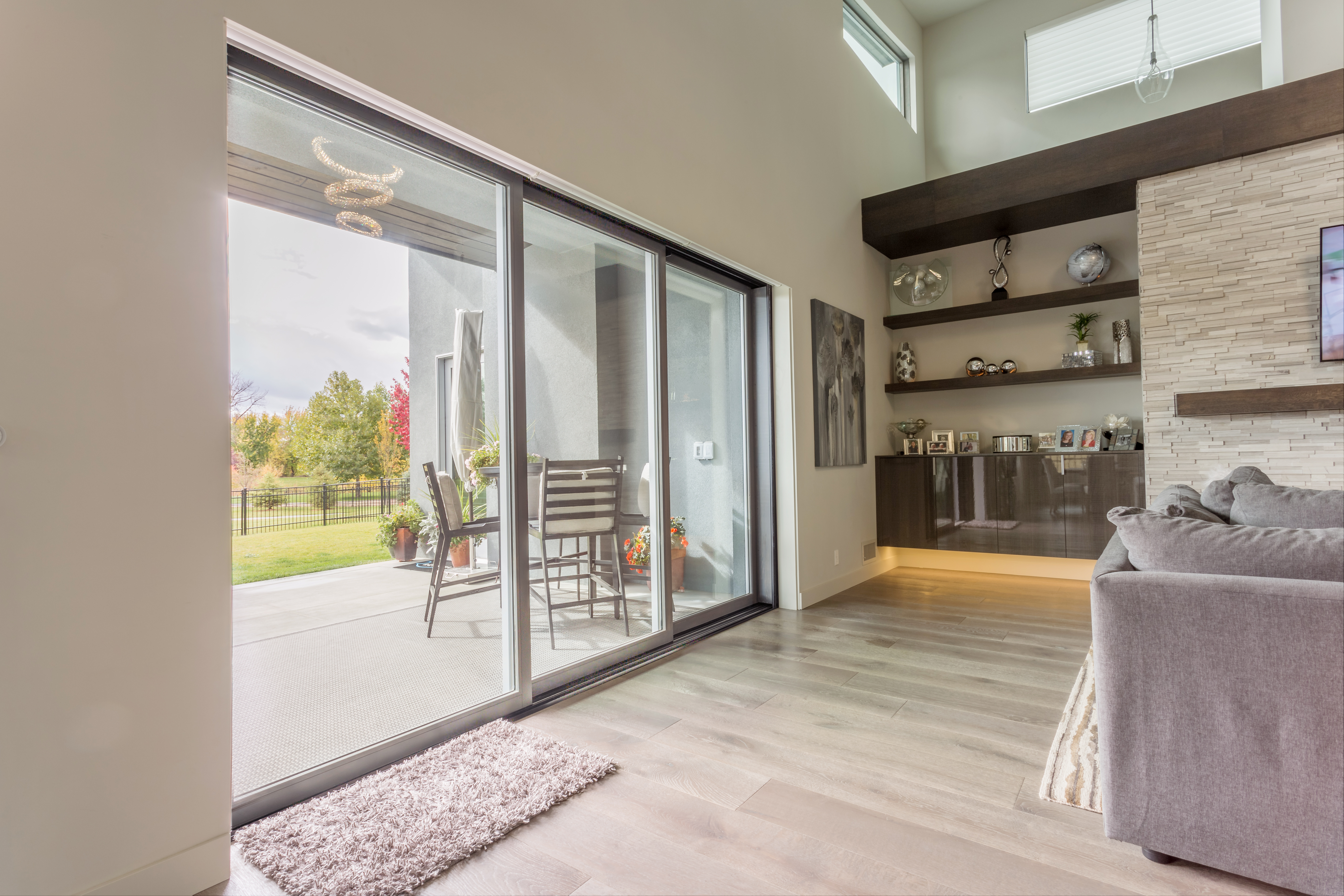 A multi-slide patio door in a living room that is fully closed with a covered porch on the outside