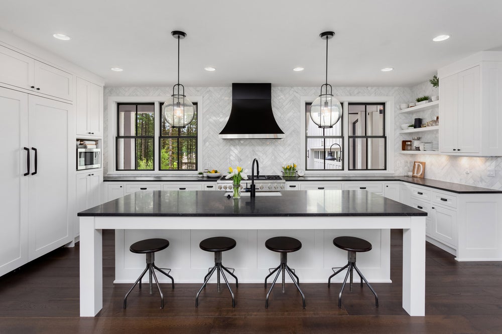 A beautiful kitchen in black and white with wooden flooring