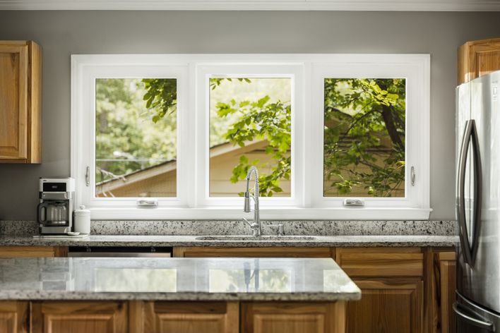 A kitchen with a sink and vinyl windows.