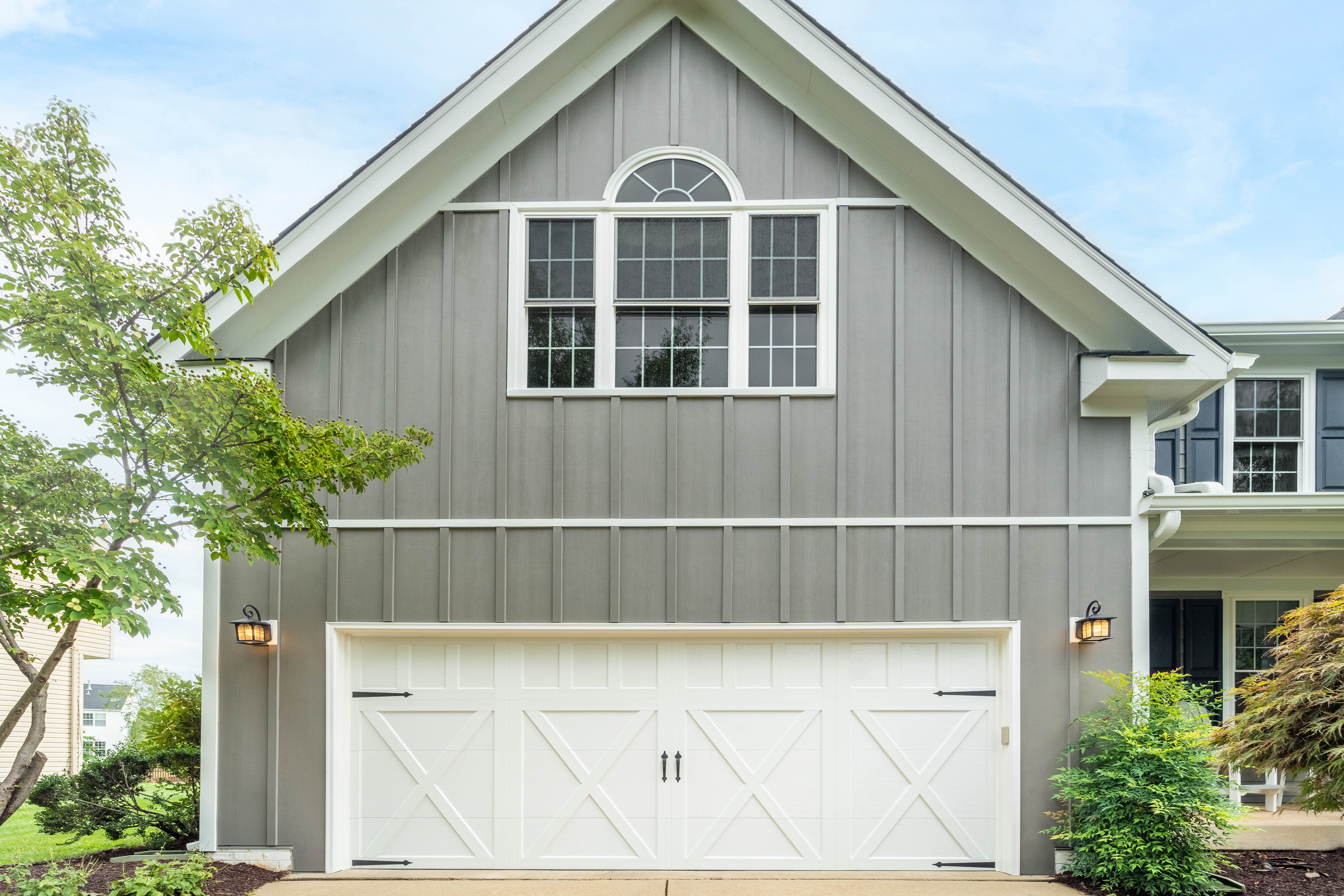 An attached garage with hardie plank, panel, soffit and trim in Aged Pewter and Artic White