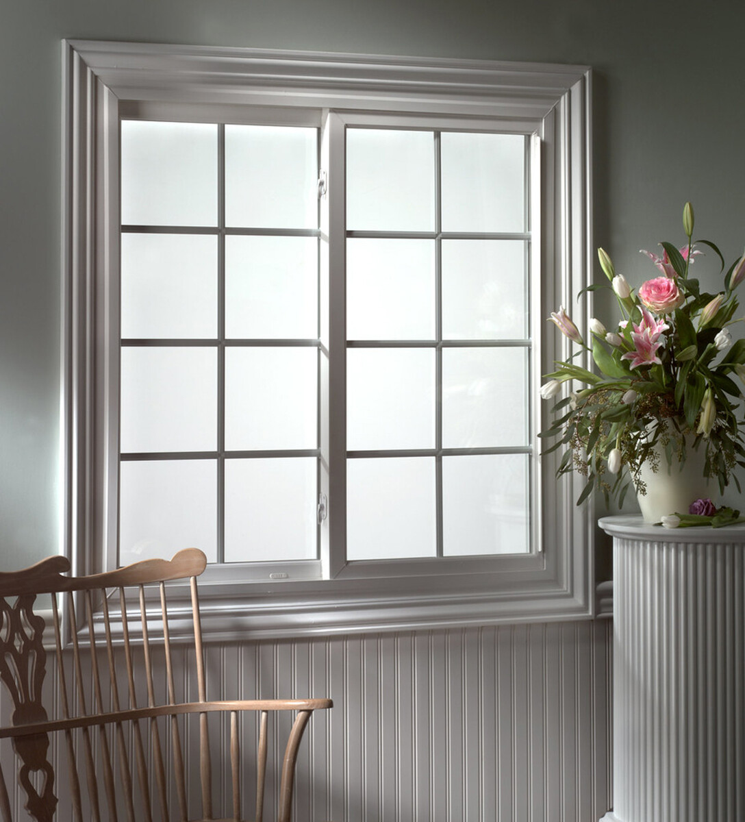 sliding window with a colonial grid in traditional reading nook with rocking chair