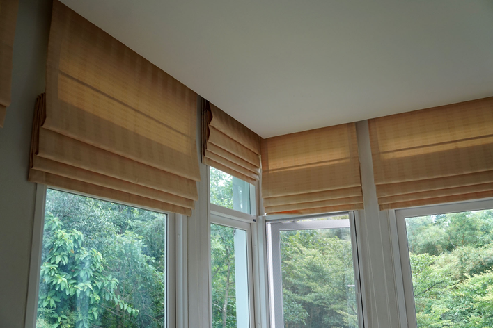 Roman shades over several windows, a common choice for modern window treatments.