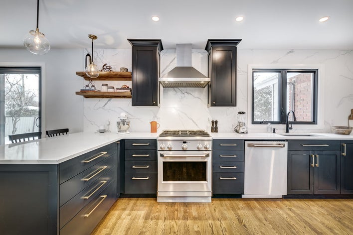 a kitchen with white countertops and black cabinets a kitchen with white countertops and black cabinets