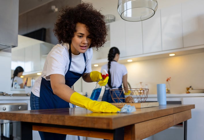 Group of women cleaning up a new home as part of a cleaning service.