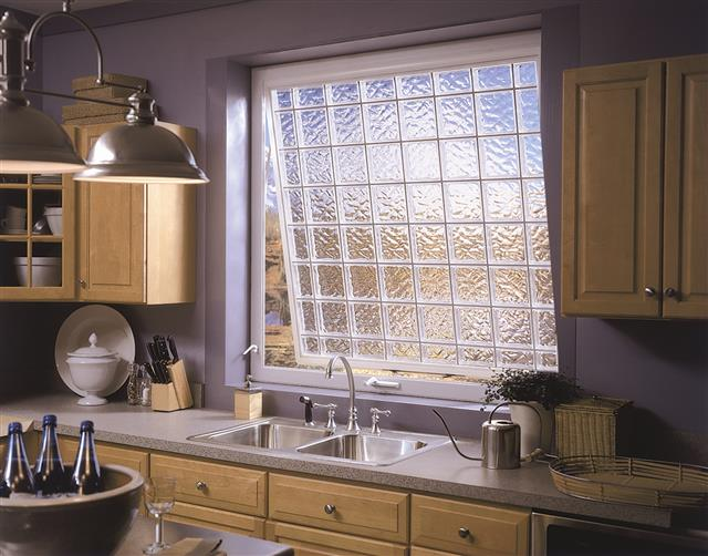 A large awning window with an obscuring privacy finish over a kitchen sink.