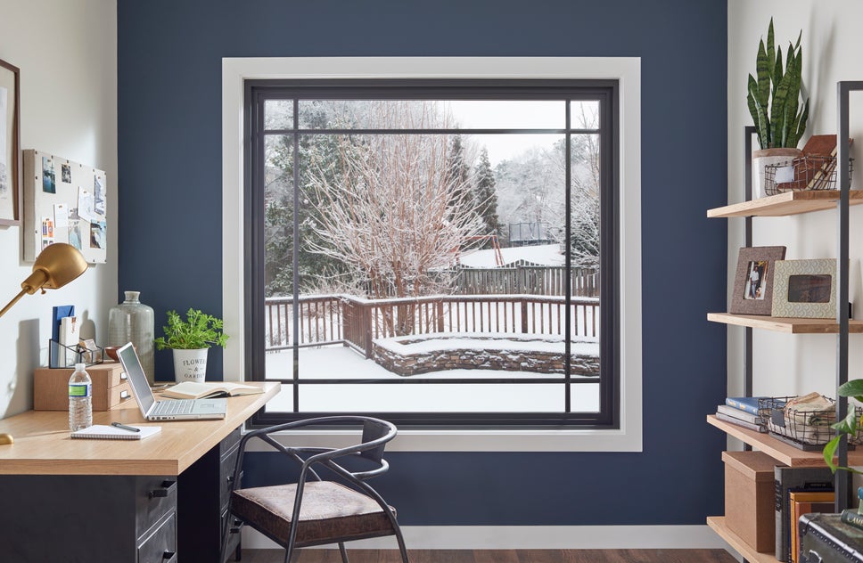 An office with a large picture window showing a snowy landscape outside