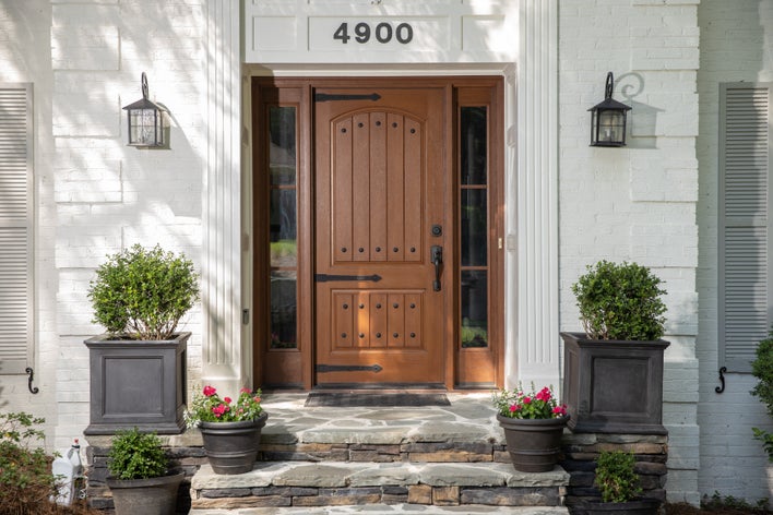 A large woodgrain energy-efficient entry door with contrasting hardware A large woodgrain energy-efficient entry door with contrasting hardware