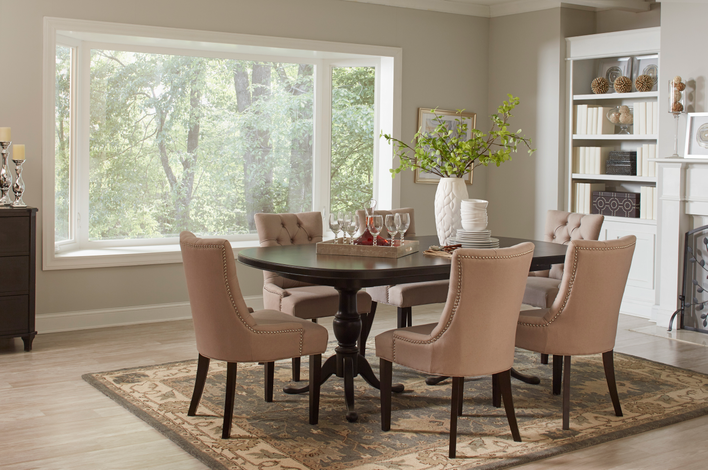 A traditional dining room with a modern bay window with a wooded view. 