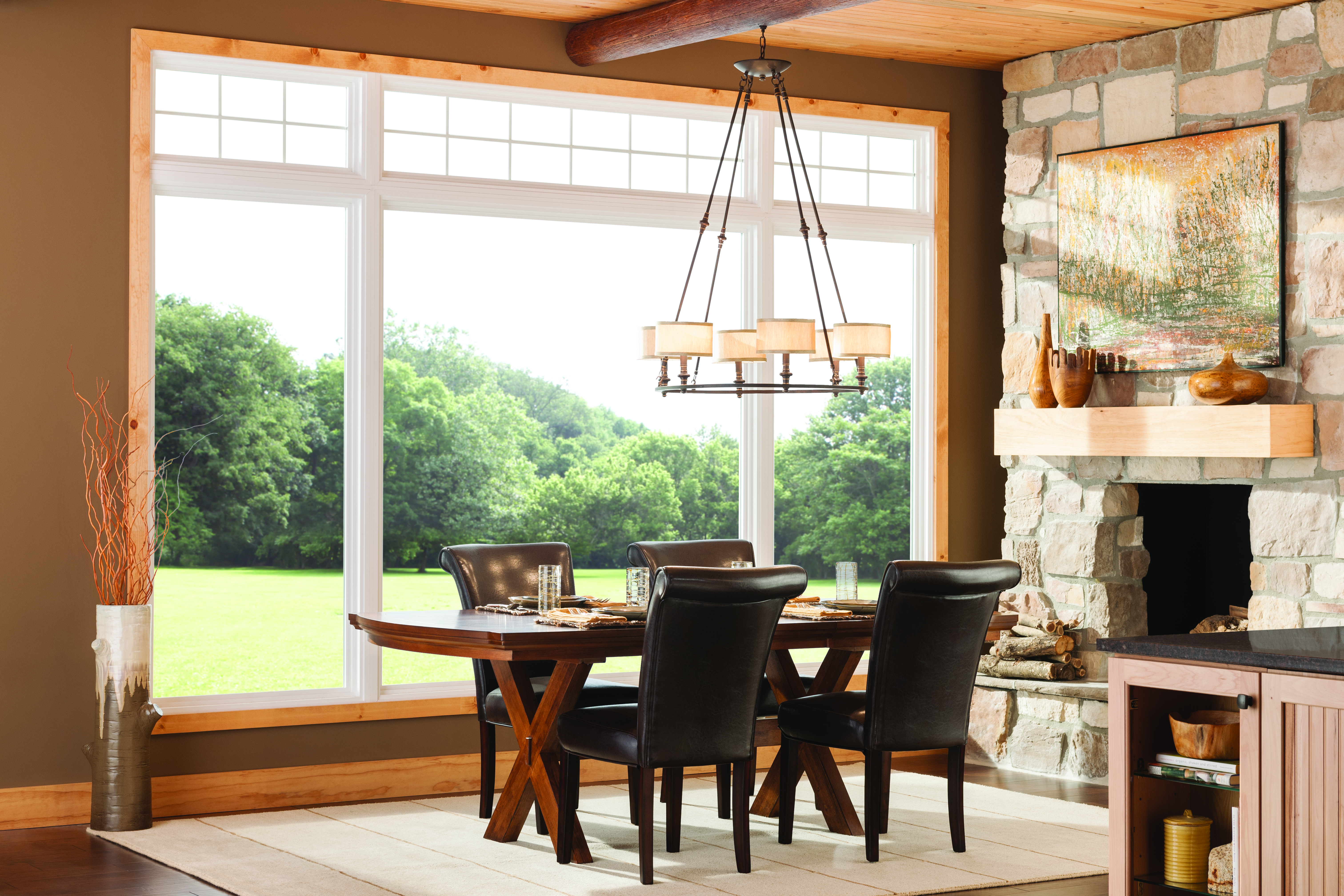 Dining room of a home including a table with four chairs around it situated in front of expansive energy-efficient picture windows.