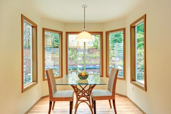 Well-lit dining room of a home surrounded by large window replacements