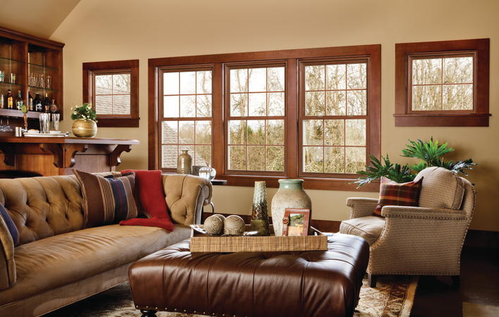 A living room with combined window material types — vinyl window frames with wooden molding to match the room.