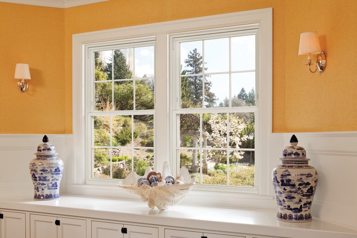Modern window styles behind more traditional décor and accessories strike a great balance.