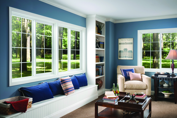 Bedroom of a home with blue-colored walls and an array of custom sliding windows.