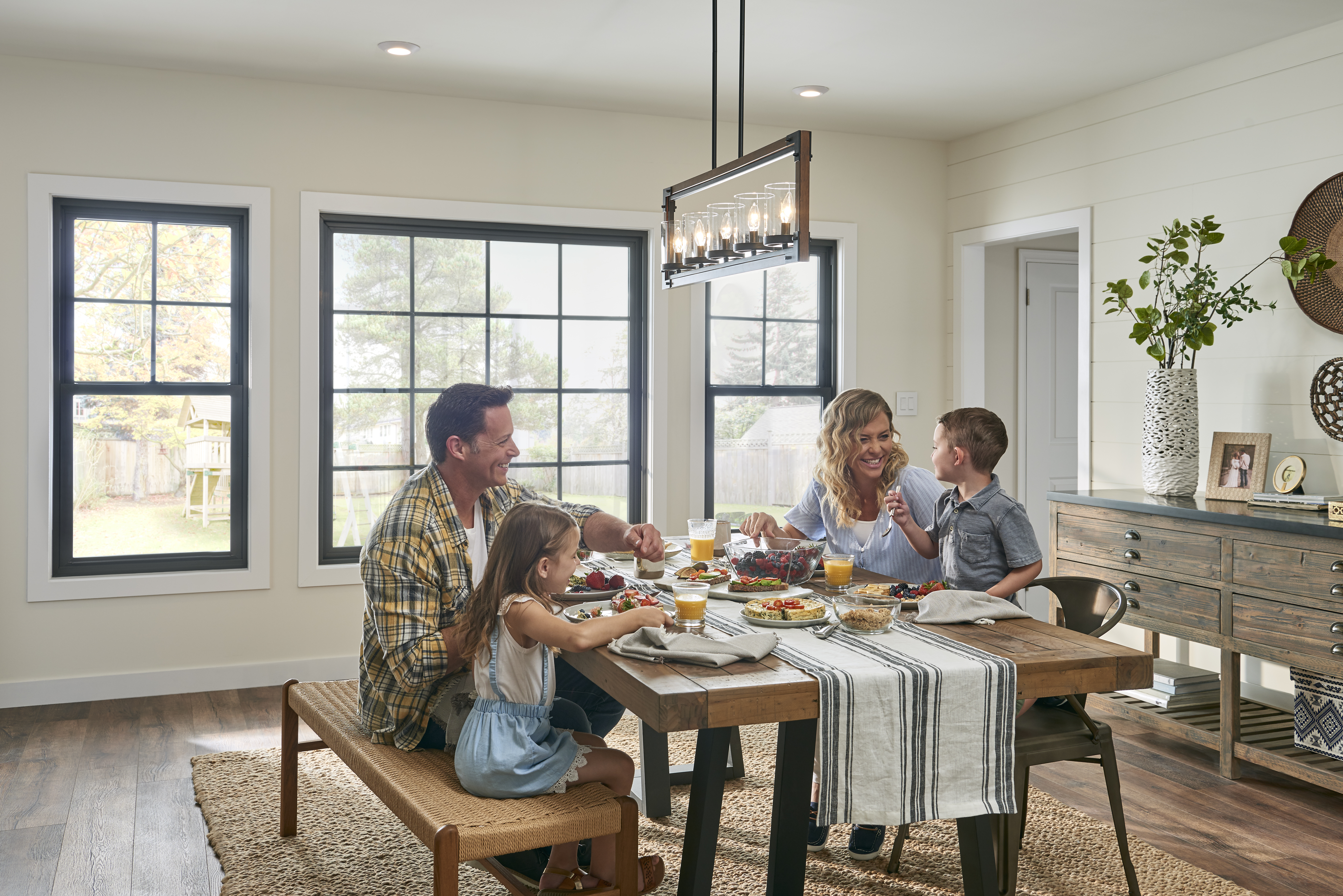 A family having breakfast in a dining room with custom windows on the wall.