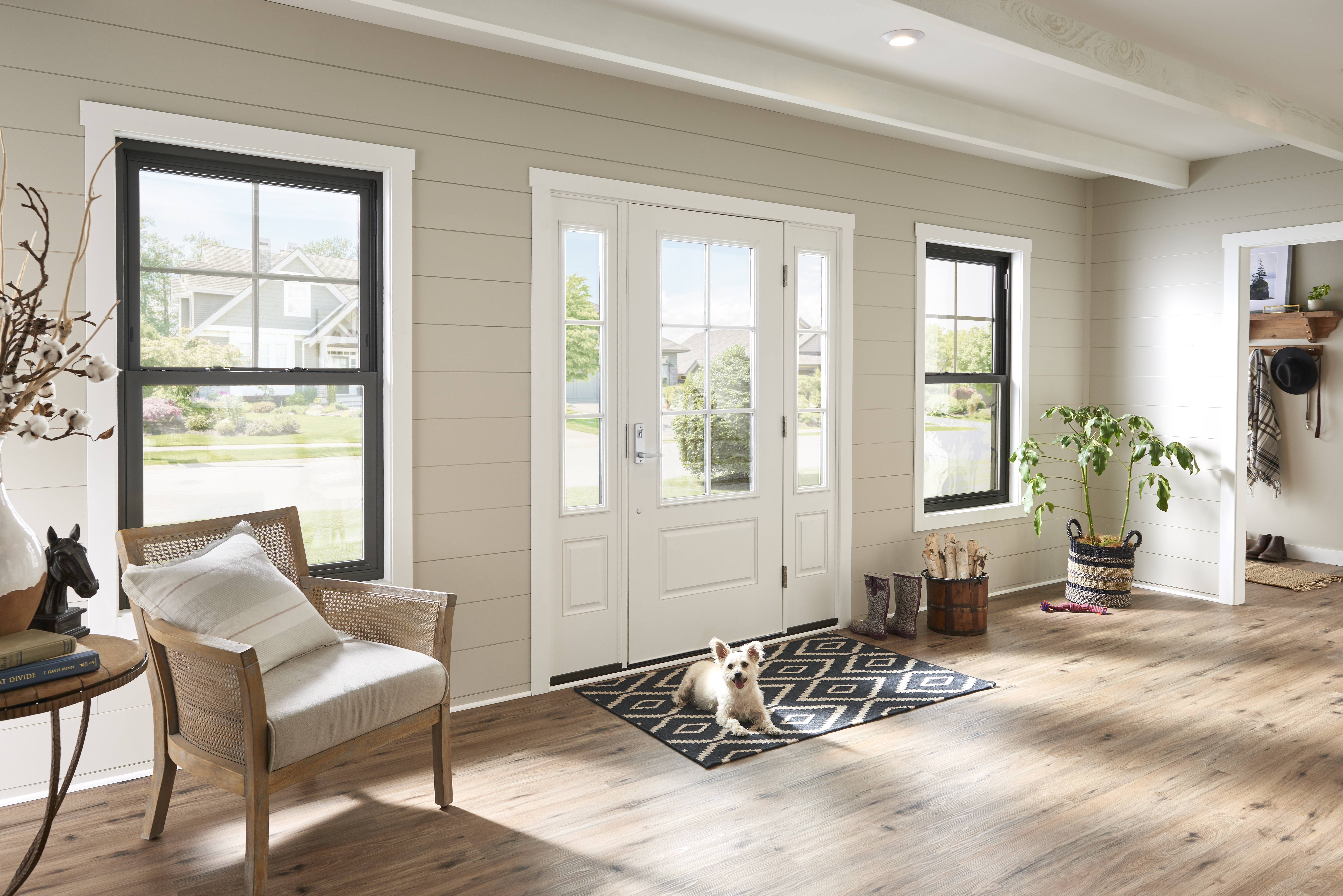 A white fiberglass door flanked by sidelites and windows allowing lots of natural light<br>into the entryway of a home.