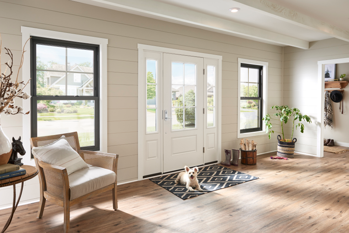 A white fiberglass door flanked by sidelites and windows allowing lots of natural light<br>into the entryway of a home.