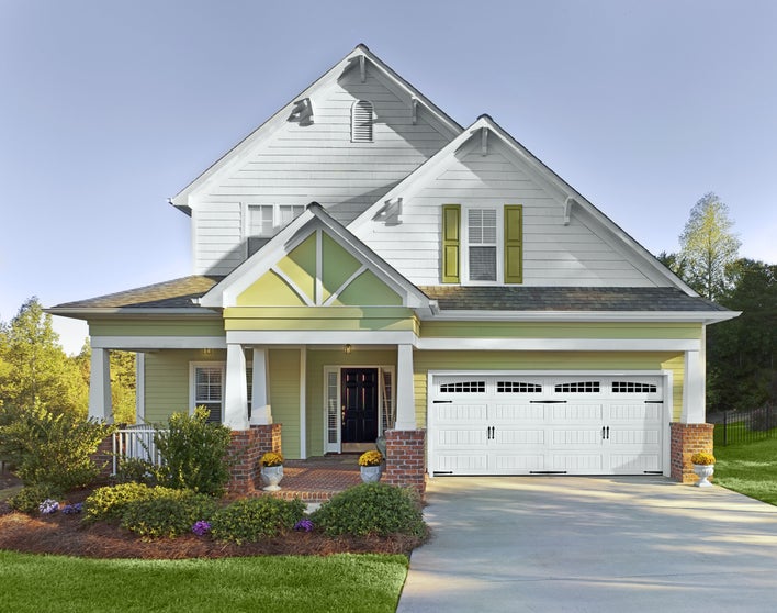 White and yellow house with green shutters.