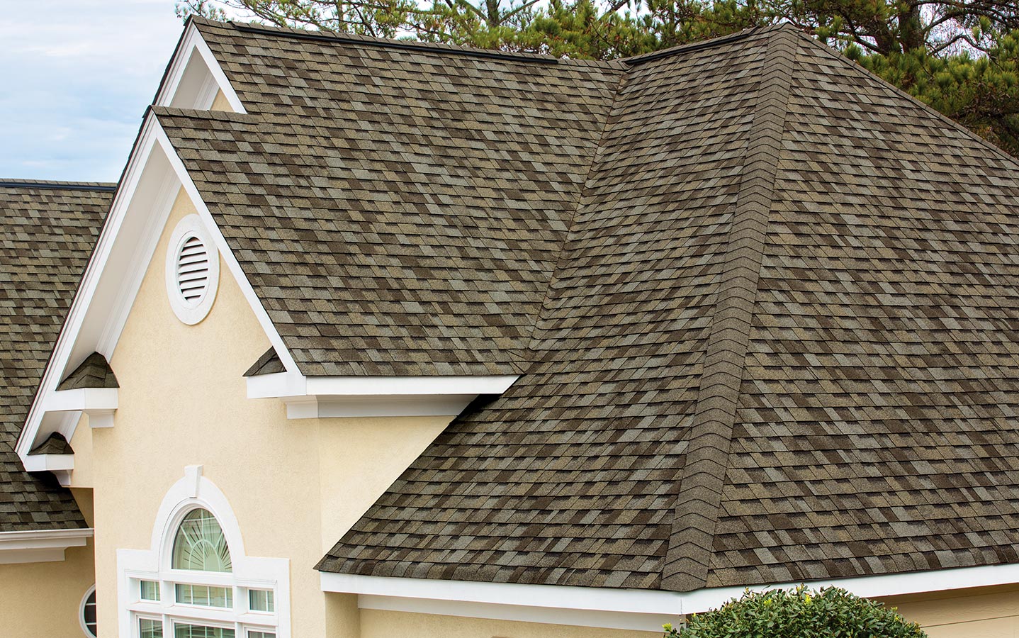 Close-up of a cream colored home with Owens Corning's TruDefinition Duration shingle line in the color Driftwood