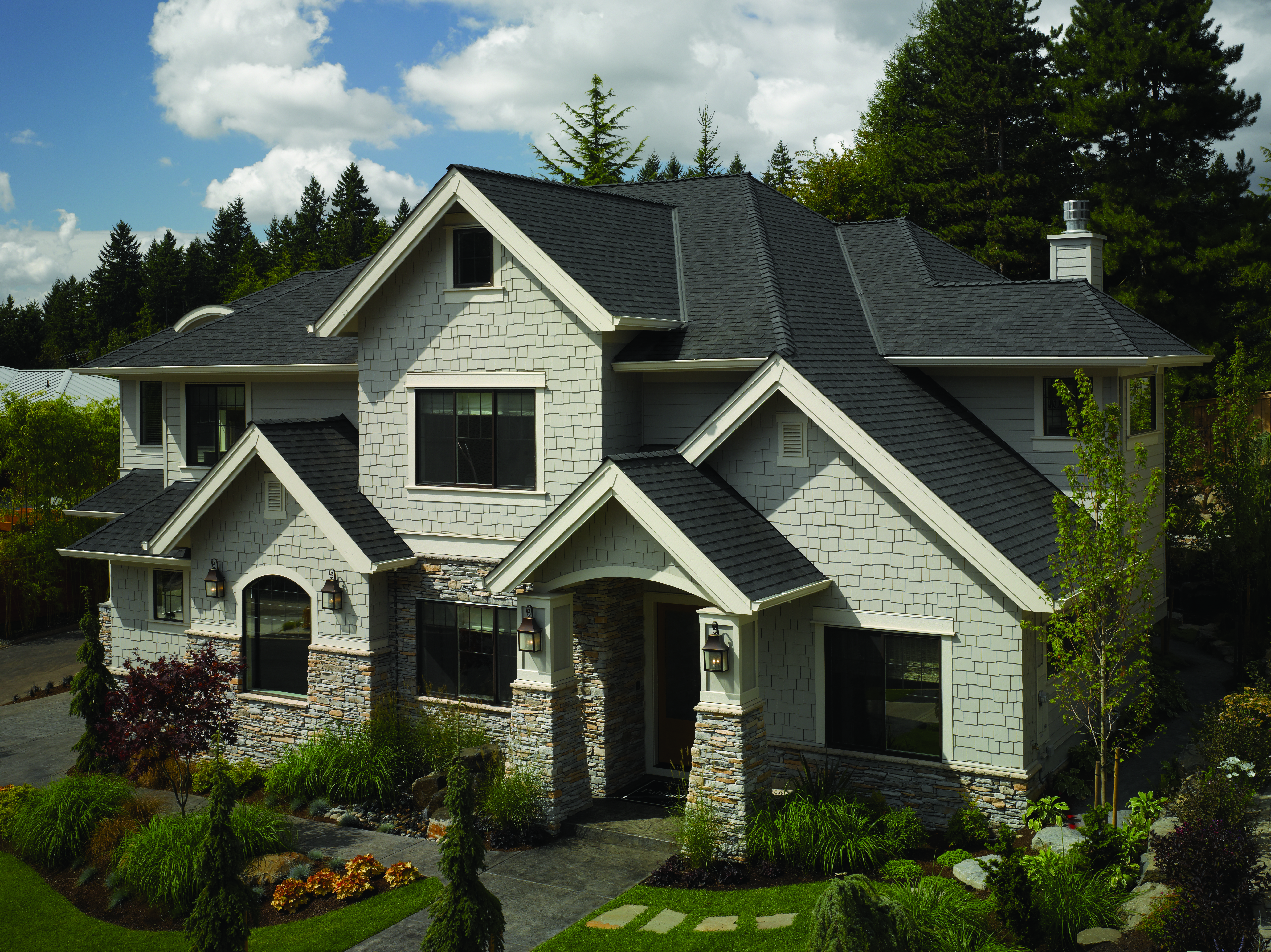 Large modern home with shake and stone siding with CertainTeed's Landmark shingle line in the color Moire Black.