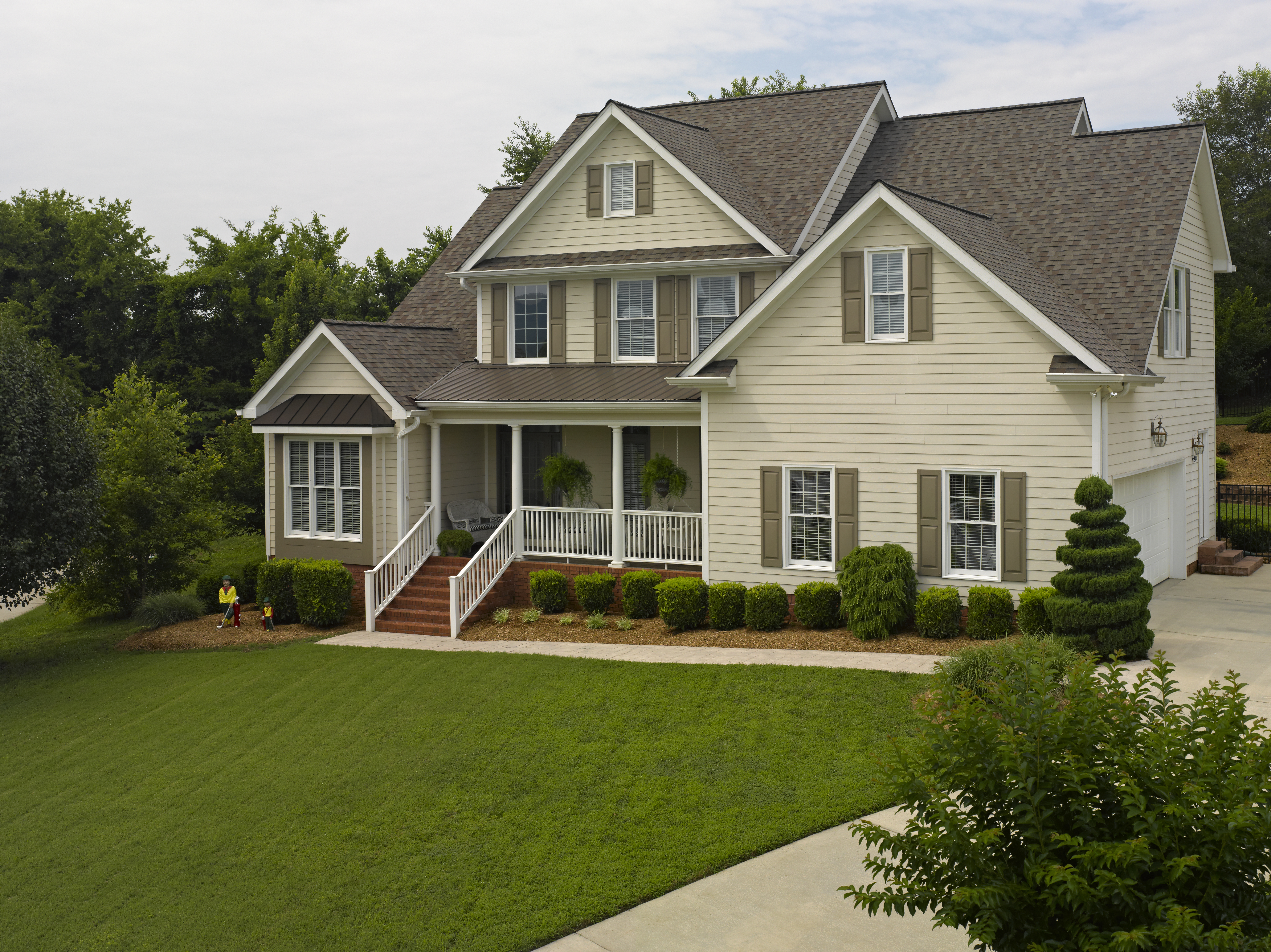 House with brown shutters and yellow siding.