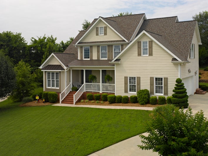 House with brown shutters and yellow siding.