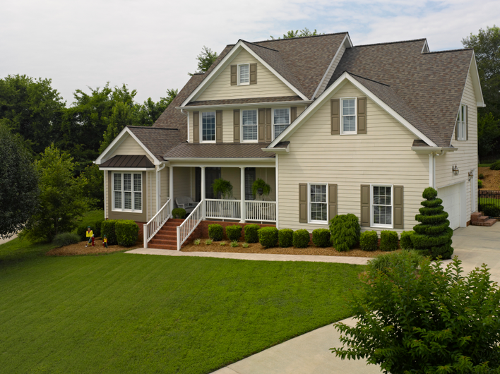 House with brown shutters and yellow siding.