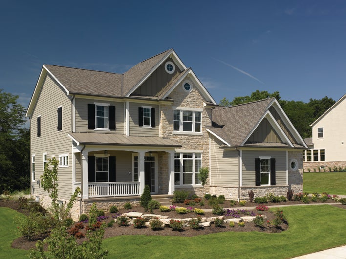 An attractive home with two types of roof materials: asphalt shingles and corrugated metal.