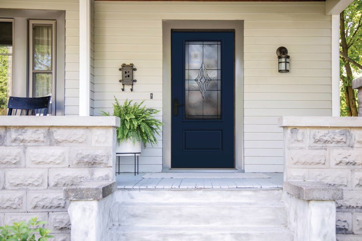 A front porch with a dark blue energy-efficient door contrasted by light-colored siding A front porch with a dark blue energy-efficient door contrasted by light-colored siding